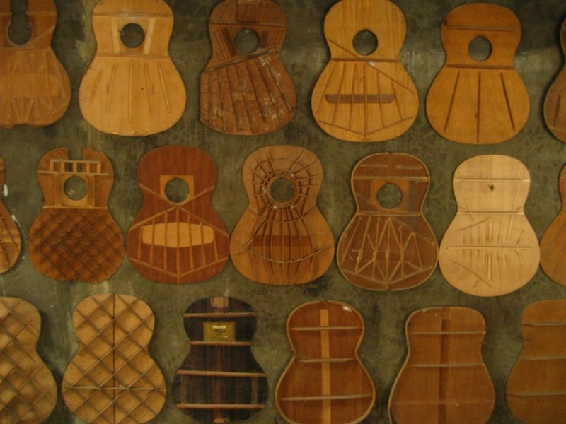 Wall of guitar tops in a Cebu factory showing fan, X, ladder, and lattice bracing patterns